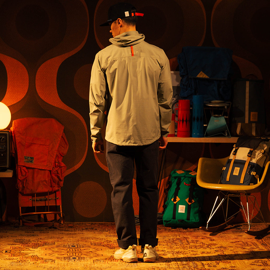 General back image of a man wearing a global jacket in "Oil Green"