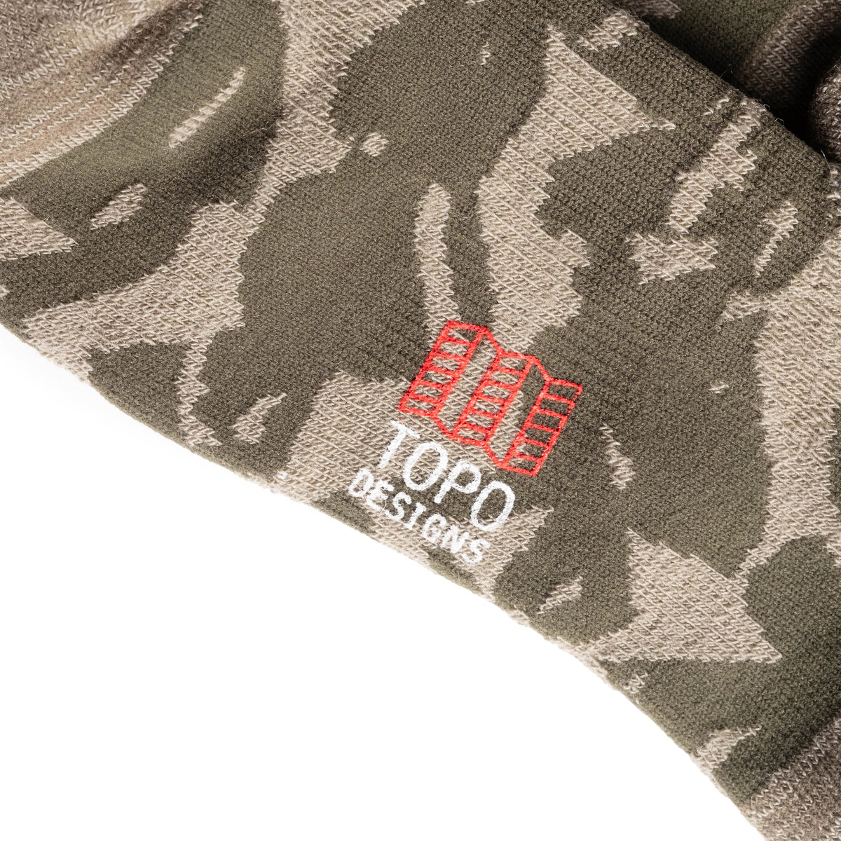 Logo detail shot of Topo Designs Town Socks in "Oil Green Geo"